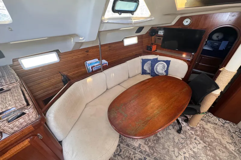 Slide: The Image of Cozy interior of 1992 Hunter Passage 42 sailboat with wooden table and cushioned seating. - 71