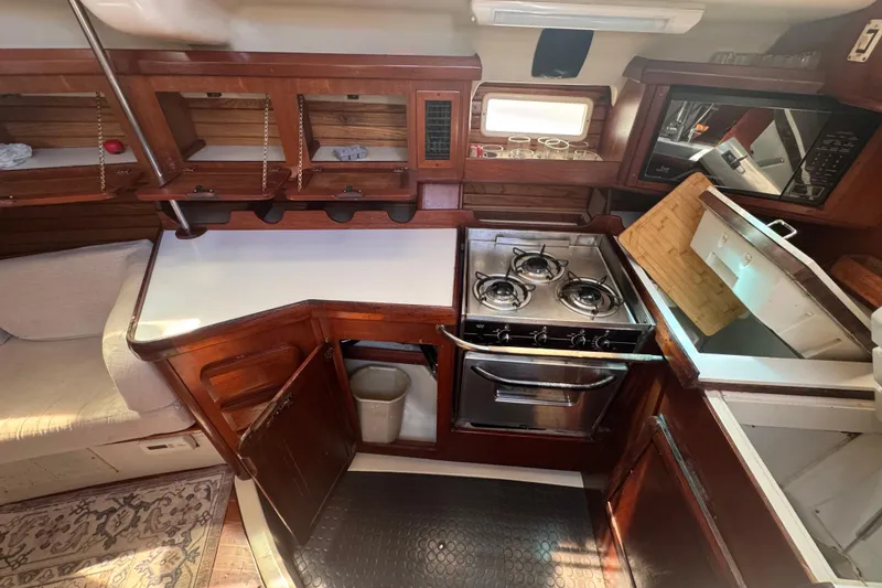 Slide: The Image of Interior of 1992 Hunter Passage 42 yacht kitchen with stove, storage, and seating area. - 73