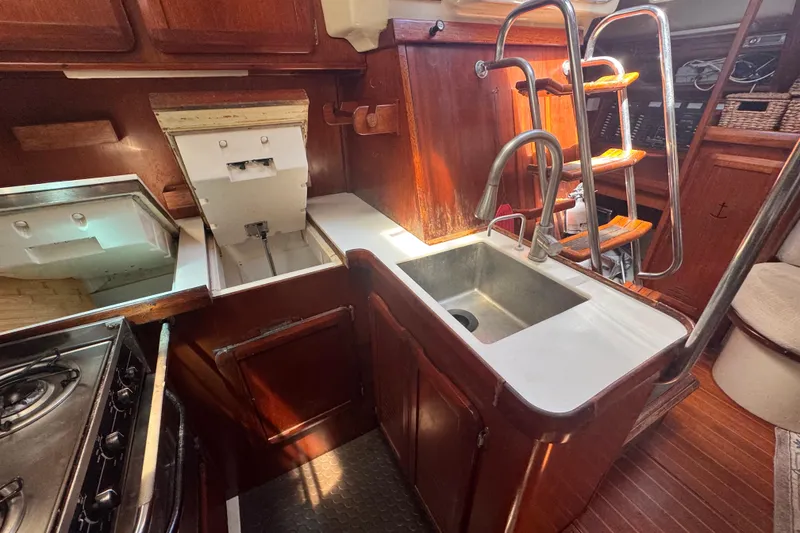 Slide: The Image of Interior of 1992 Hunter Passage 42 sailboat kitchen with sink, stove, and wooden cabinetry. - 79