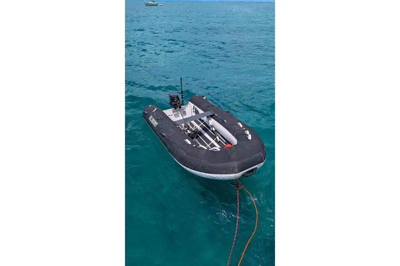 Slide: The Image of Inflatable boat on turquoise water, near a 1992 Hunter Passage 42 yacht. - 8