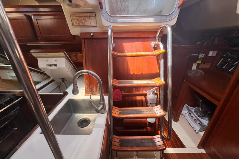 Slide: The Image of Interior of 1992 Hunter Passage 42 sailboat with wooden stairs and kitchen sink. - 80
