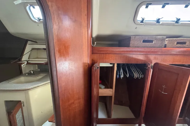 Slide: The Image of Interior of 1992 Hunter Passage 42 sailboat with wooden cabinetry and storage space. - 84