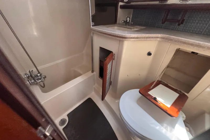 Slide: The Image of 1992 Hunter Passage 42 yacht bathroom with shower, sink, and storage compartments. - 85