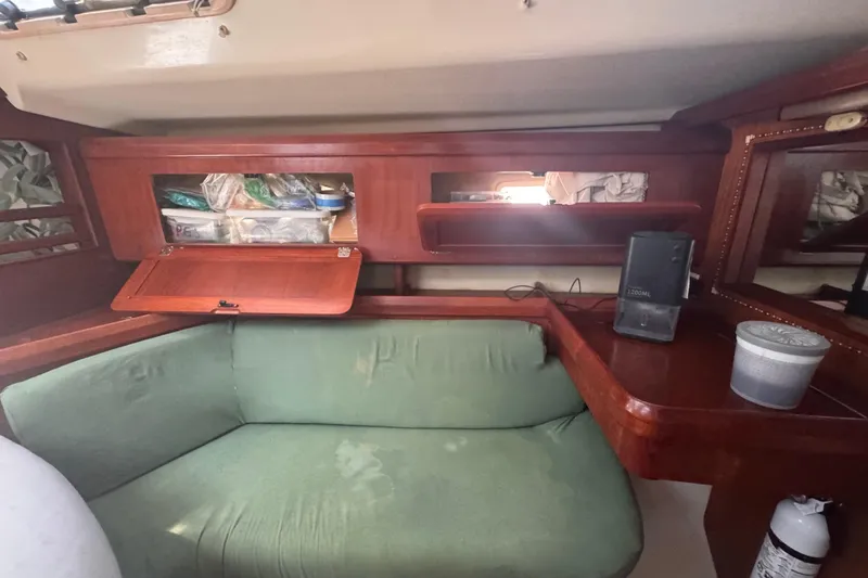 Slide: The Image of Interior of 1992 Hunter Passage 42 yacht with green seating and wooden storage compartments. - 86