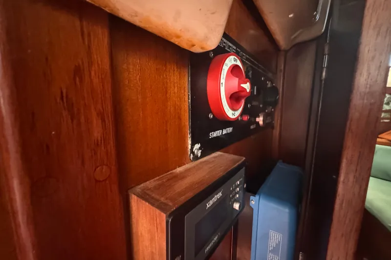 Slide: The Image of Electrical panel inside 1992 Hunter Passage 42 sailboat, featuring starter battery switch and Xantrex system. - 87