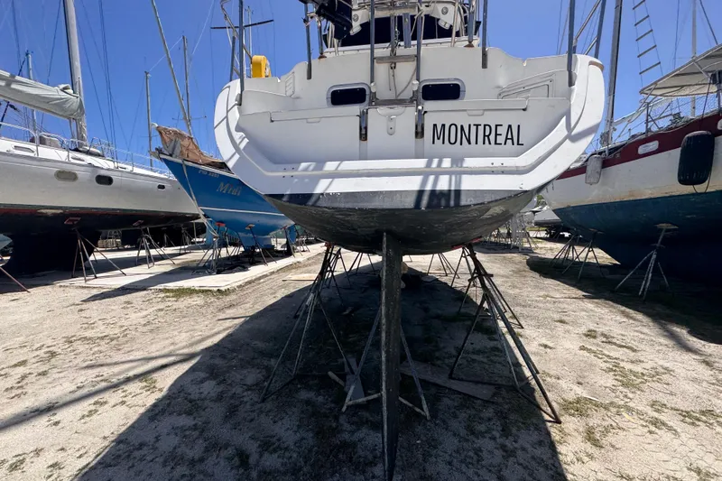 Slide: The Image of 1992 Hunter Passage 42 sailboat named "Montreal" on dry dock, surrounded by other boats. - 9