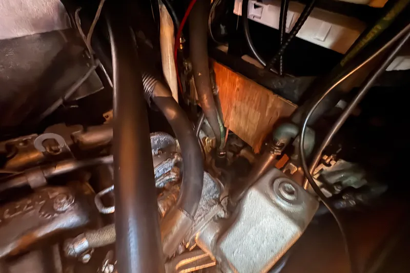 Slide: The Image of Engine compartment of a 1992 Hunter Passage 42 sailboat, showing hoses and mechanical components. - 91