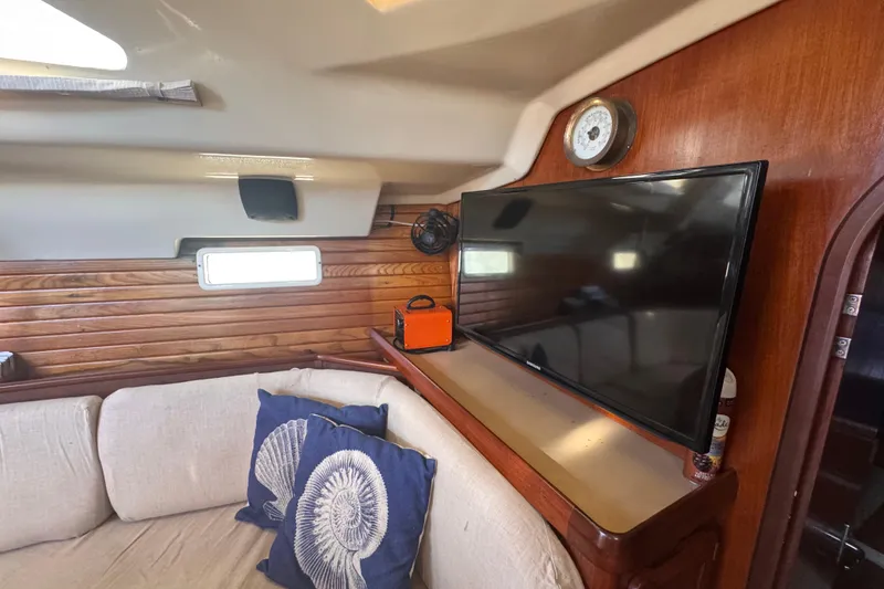 Slide: The Image of Interior of 1992 Hunter Passage 42 yacht with cozy seating and modern TV setup. - 93
