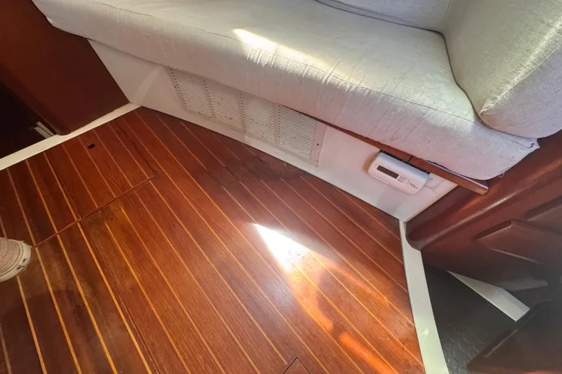 Slide: The Image of Interior of 1992 Hunter Passage 42 yacht with wooden flooring and cushioned seating. - 99