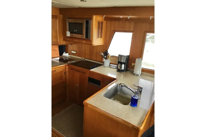 Slide: The Image of Luxurious 2008 Grand Banks 59 Aleutian RP yacht kitchen with wood cabinetry and modern appliances. - 16
