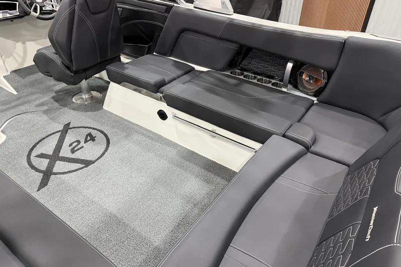 Slide: The Image of 2021 MasterCraft X24 boat interior with sleek black seating and custom carpet design. - 11