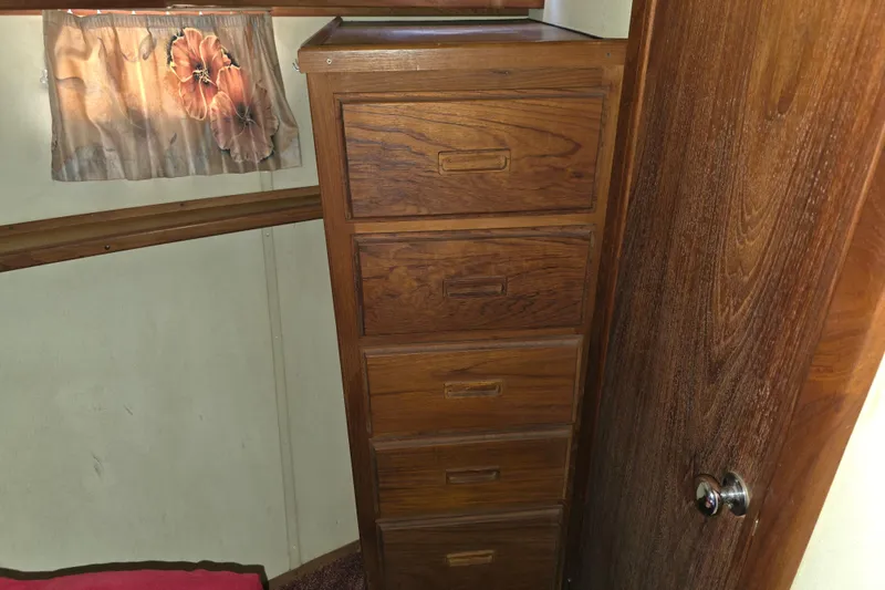 Slide: The Image of 1988 Marinette 37 Motor Yacht interior with wooden drawers and floral curtain. - 45