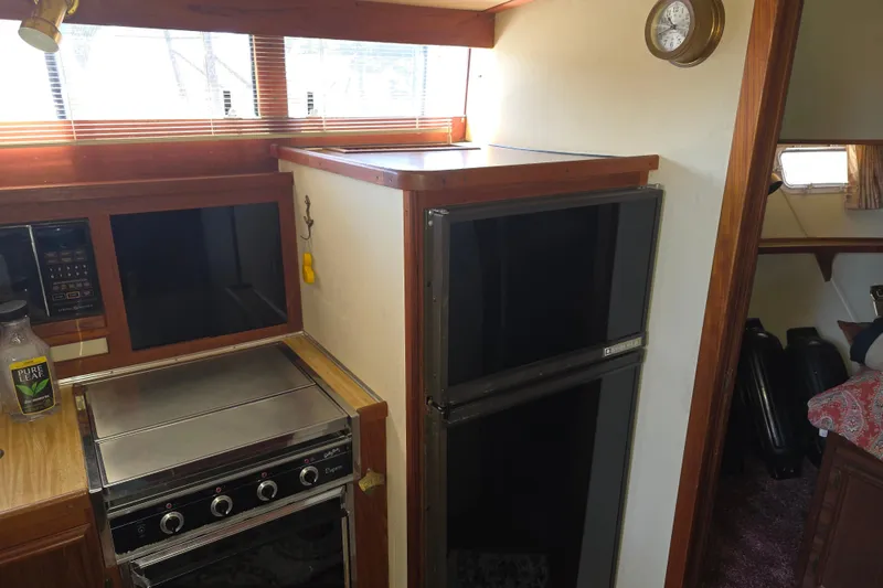 Slide: The Image of 1988 Marinette 37 Motor Yacht kitchen with stove, fridge, and clock. - 49