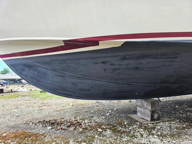 Slide: The Image of 1988 Marinette 37 Motor Yacht hull on dry dock, showcasing black and red paint. - 6