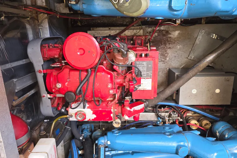 Slide: The Image of Engine room of a 1988 Marinette 37 Motor Yacht, featuring red and blue machinery components. - 62