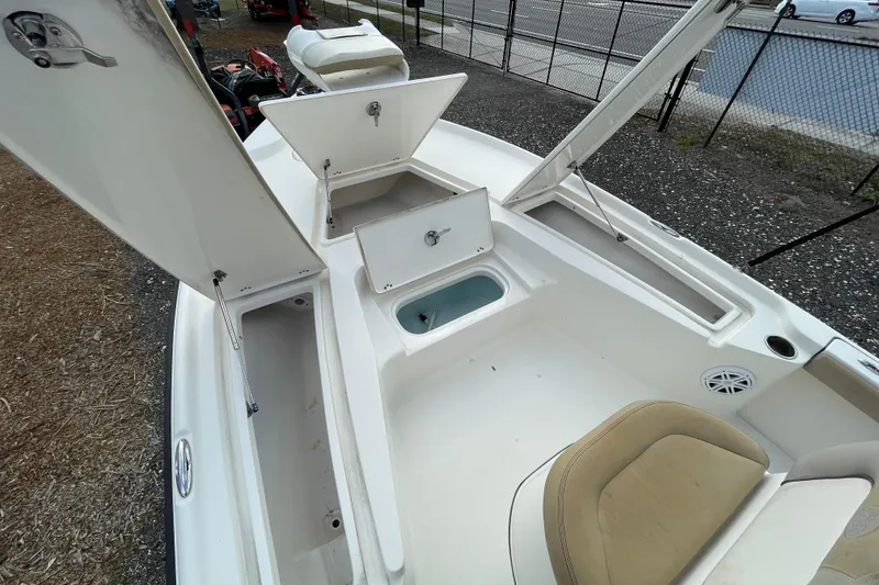 Slide: The Image of 2014 Key West 210 Bay Reef boat with open storage compartments and seating area. - 16
