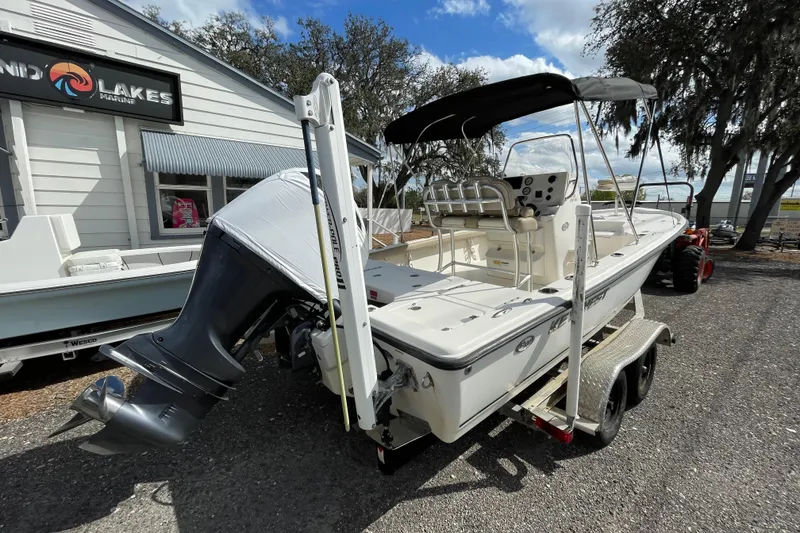 Slide: The Image of 2014 Key West 210 Bay Reef boat on trailer, parked outside a marine shop. - 3