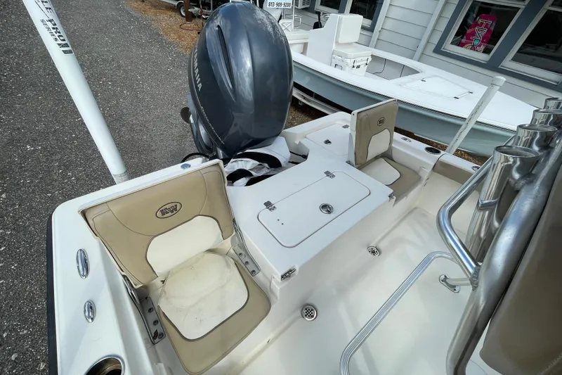 Slide: The Image of 2014 Key West 210 Bay Reef boat interior with Yamaha engine, beige seating, and rod holders. - 6