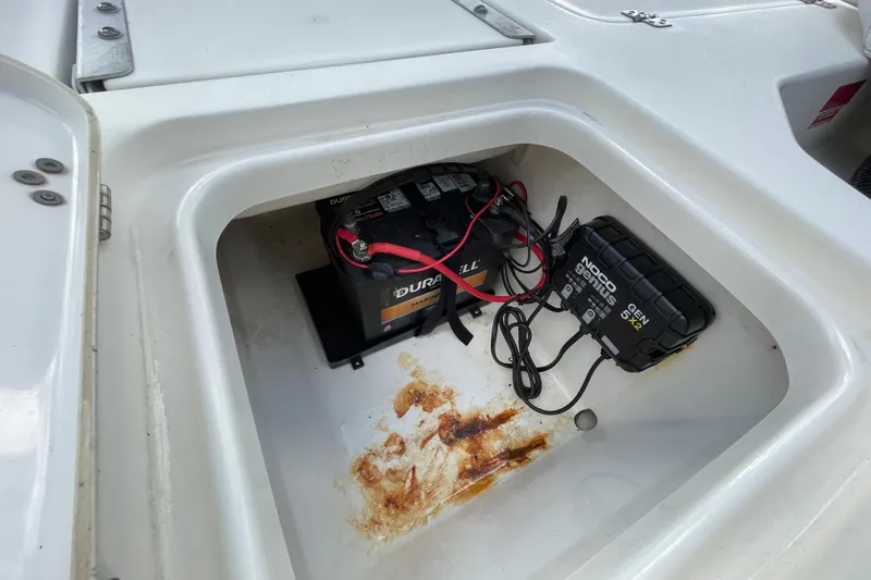 Slide: The Image of 2014 Key West 210 Bay Reef boat battery compartment with Duracell battery and NOCO Genius charger. - 7