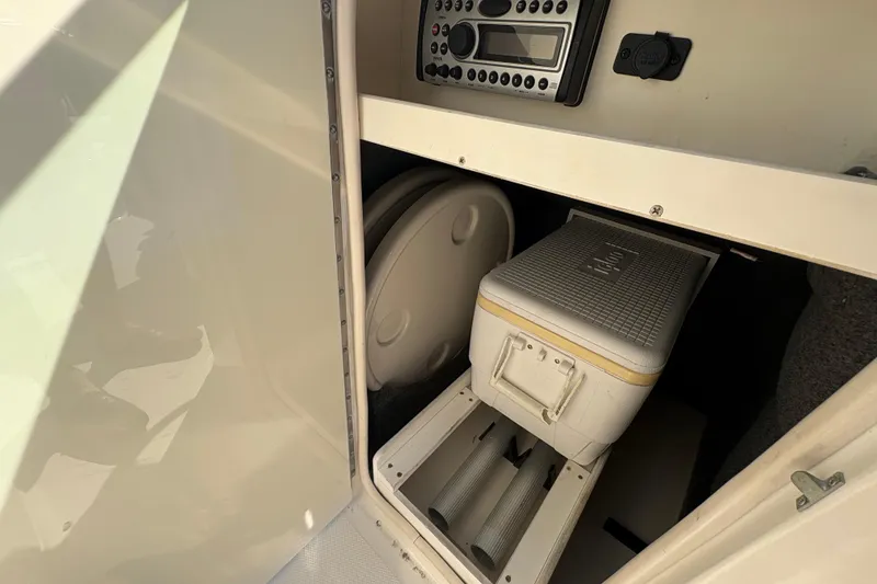 Slide: The Image of 2011 Sea Ray 185 Sport interior storage with cooler and control panel. - 10