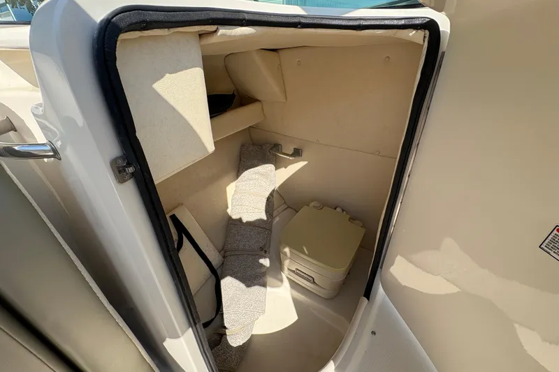 Slide: The Image of 2011 Sea Ray 185 Sport boat interior storage compartment with portable toilet. - 11