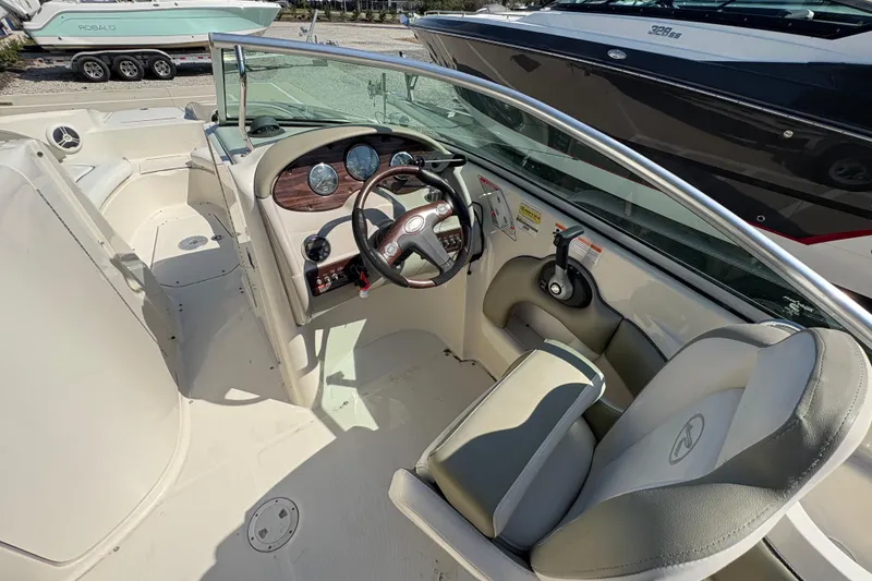 Slide: The Image of 2011 Sea Ray 185 Sport boat interior with steering wheel and dashboard controls. - 13