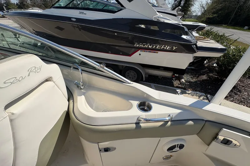 Slide: The Image of 2011 Sea Ray 185 Sport interior with sink, cup holder, and Monterey boat in background. - 17
