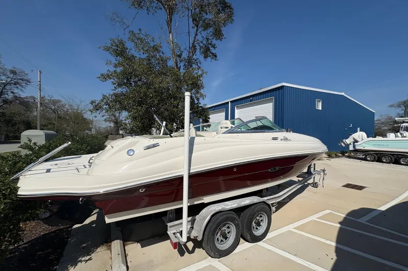 Slide: The Image of 2011 Sea Ray 185 Sport boat on trailer near blue building, sunny day. - 2