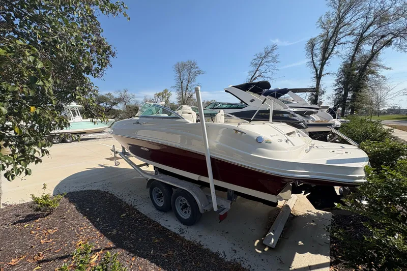 Slide: The Image of 2011 Sea Ray 185 Sport boat on trailer, parked outdoors under clear sky. - 3