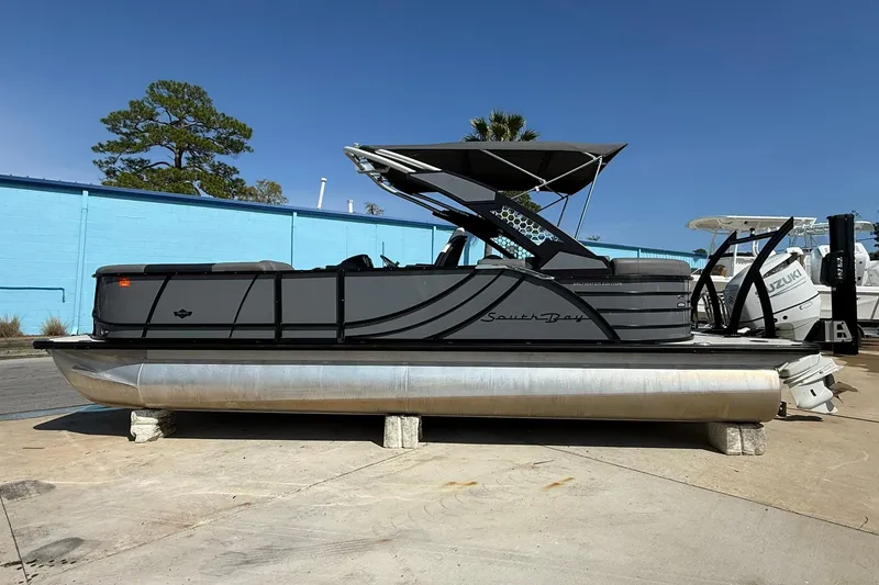 The Image of 2022 South Bay 525 RS pontoon boat with canopy, parked on concrete blocks. - 1