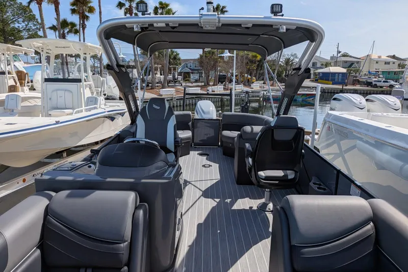 Slide: The Image of 2022 South Bay 525 RS pontoon boat interior with modern seating and helm, docked at marina. - 17