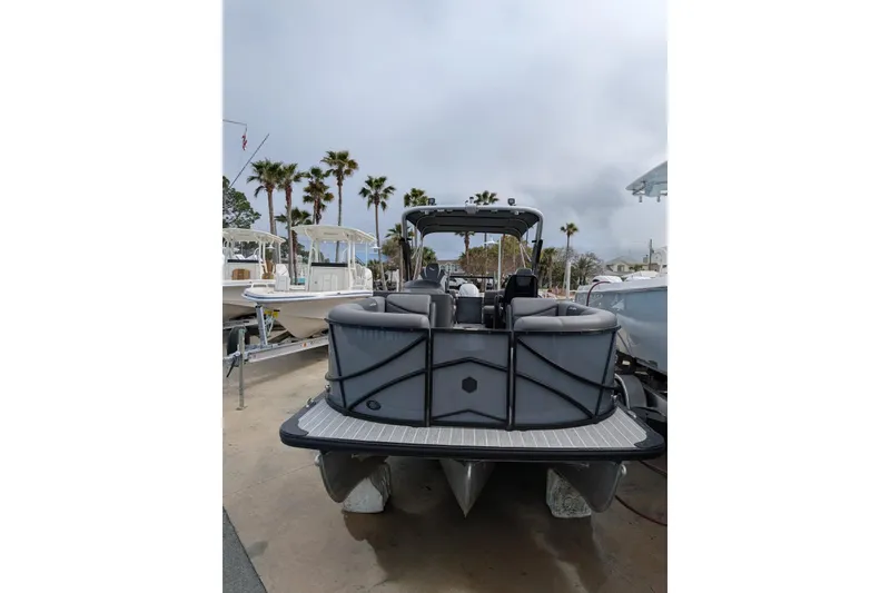 Slide: The Image of 2022 South Bay 525 RS pontoon boat, rear view, docked with palm trees in background. - 6