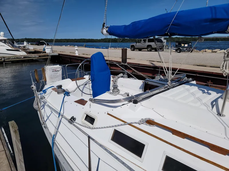 Slide: The Image of 1984 Hunter 34 sailboat docked at marina, blue sail cover, clear sky. - 18
