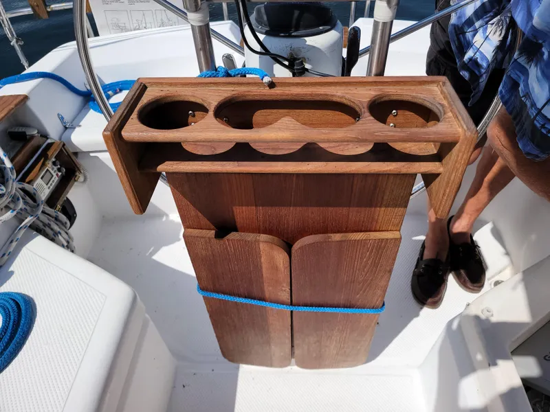 Slide: The Image of Wooden cockpit table on 1984 Hunter 34 sailboat, featuring cup holders and storage. - 24