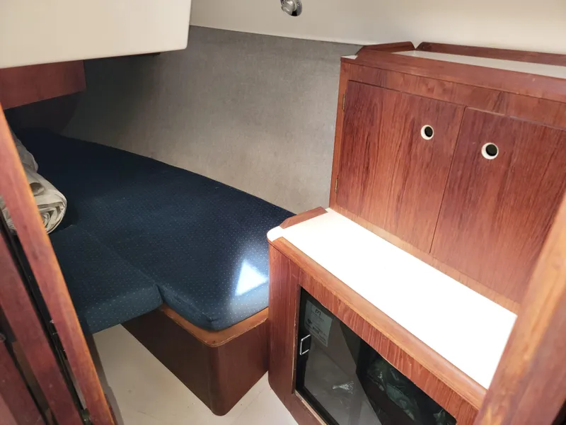 Slide: The Image of Interior cabin of 1984 Hunter 34 sailboat with wooden cabinetry and blue upholstery. - 43