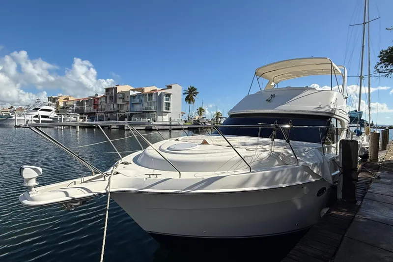 The Image of 2006 Silverton 36 Convertible yacht docked at a marina under a clear blue sky. - 1