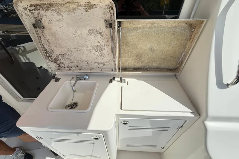 Slide: The Image of 2006 Silverton 36 Convertible boat sink and storage area with open lids. - 17