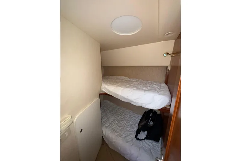 Slide: The Image of 2006 Silverton 36 Convertible cabin with bunk beds and white bedding. - 21