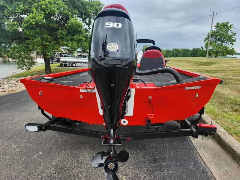 Slide: The Image of 2021 Caravelle Raptor 180 Bass boat with 90 HP engine, parked on a paved area. - 2