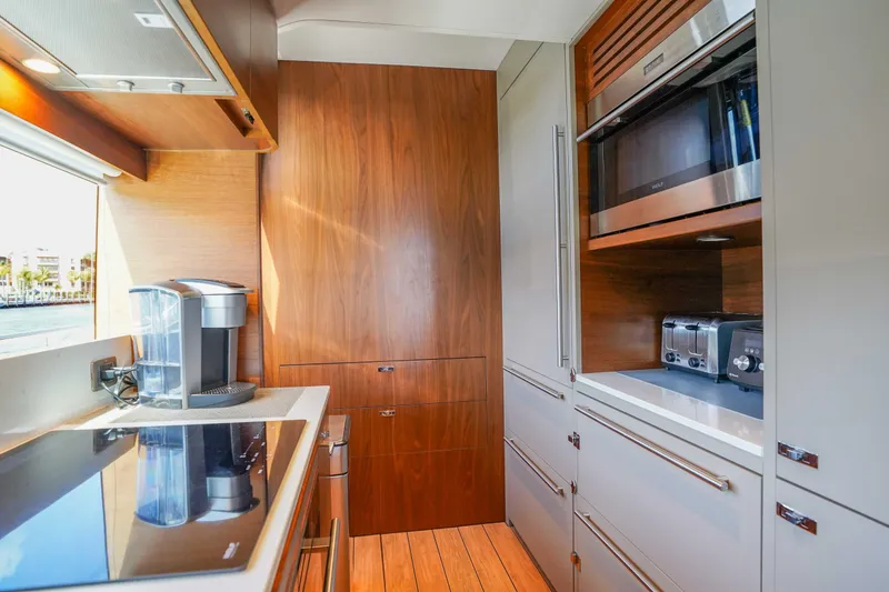 Slide: The Image of Modern kitchen interior on 2021 Princess Y85 yacht, featuring sleek appliances and wood finishes. - 19