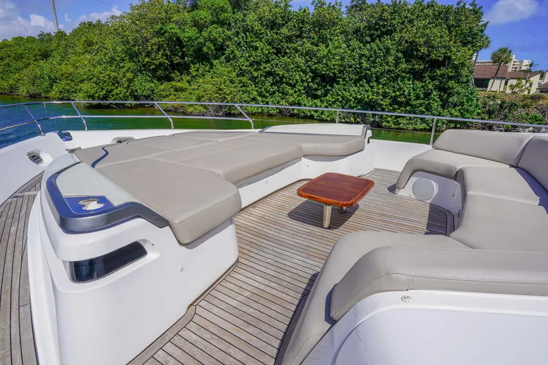 Slide: The Image of Luxurious 2021 Princess Y85 yacht deck with plush seating and wooden table, surrounded by lush greenery. - 9