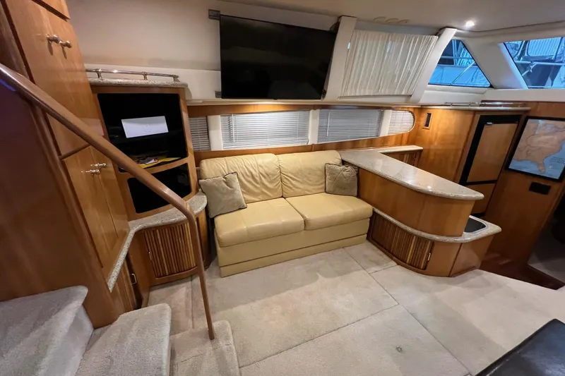 Slide: The Image of Interior of 2001 Carver 396 Motor Yacht with beige sofa and wooden cabinetry. - 10