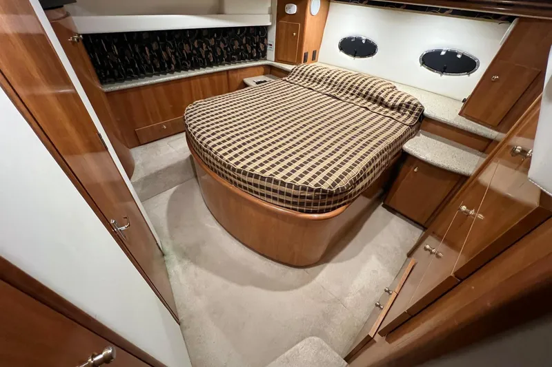 Slide: The Image of Luxurious 2001 Carver 396 Motor Yacht bedroom with elegant wood finish and cozy bed. - 18