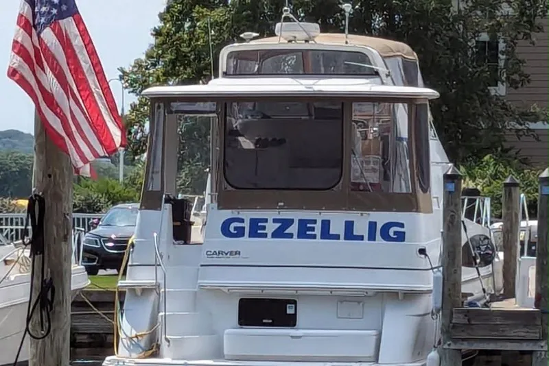 Slide: The Image of 2001 Carver 396 Motor Yacht "Gezellig" docked with American flag nearby. - 2