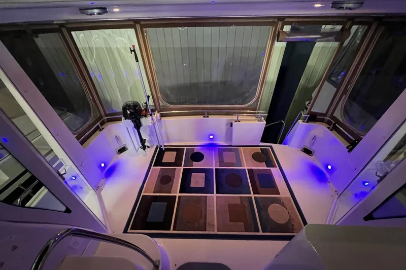 Slide: The Image of 2001 Carver 396 Motor Yacht interior with patterned rug and ambient blue lighting. - 25