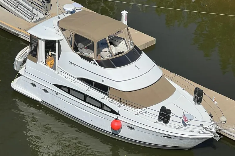 Slide: The Image of 2001 Carver 396 Motor Yacht docked in marina, featuring sleek design and beige canopy. - 4