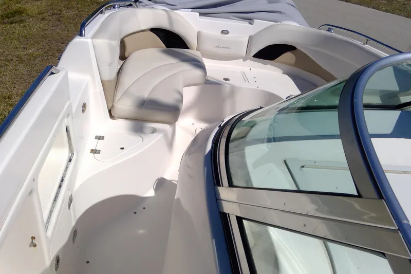 Slide: The Image of 2004 Hurricane SunDeck 260 OB boat interior with cushioned seating and windshield. - 10