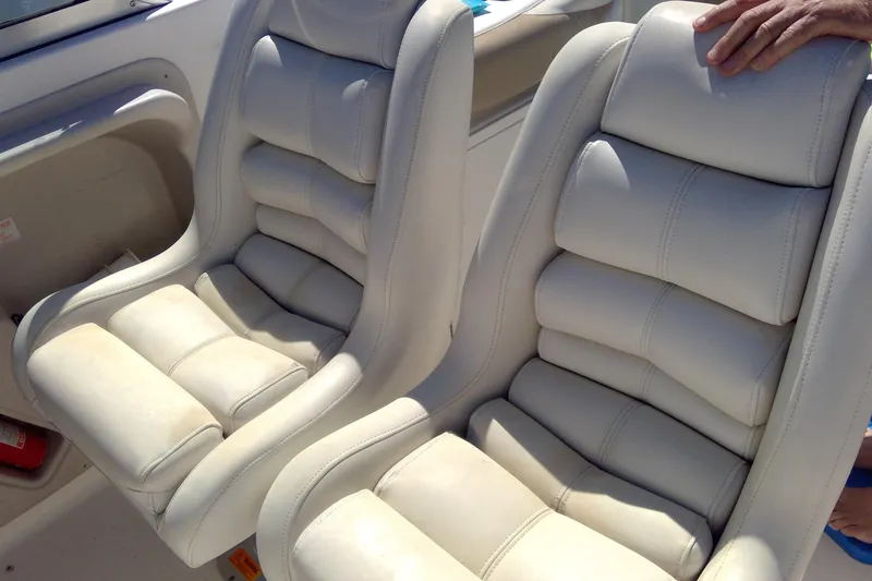 Slide: The Image of Two white cushioned seats on a 2004 Hurricane SunDeck 260 OB boat. - 12