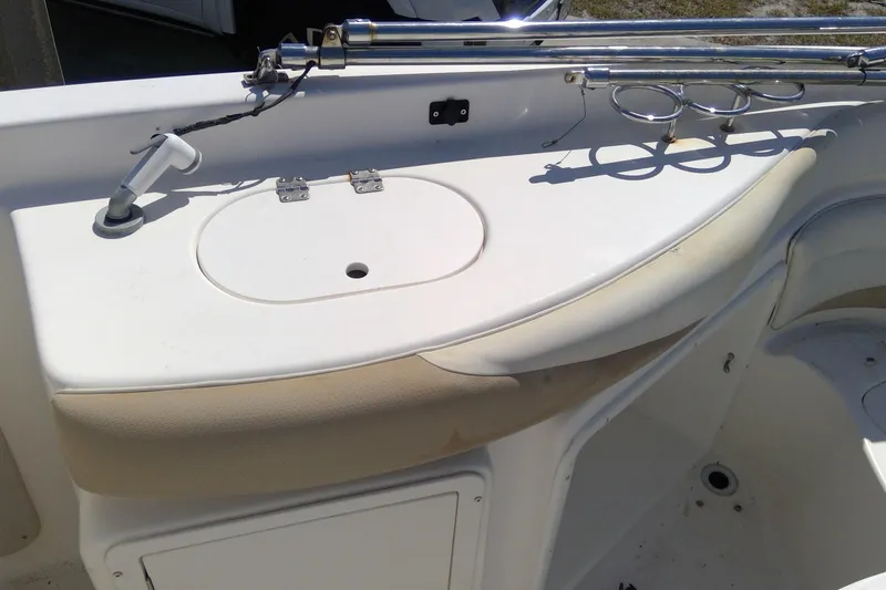 Slide: The Image of 2004 Hurricane SunDeck 260 OB boat interior with rod holders and storage compartment. - 15