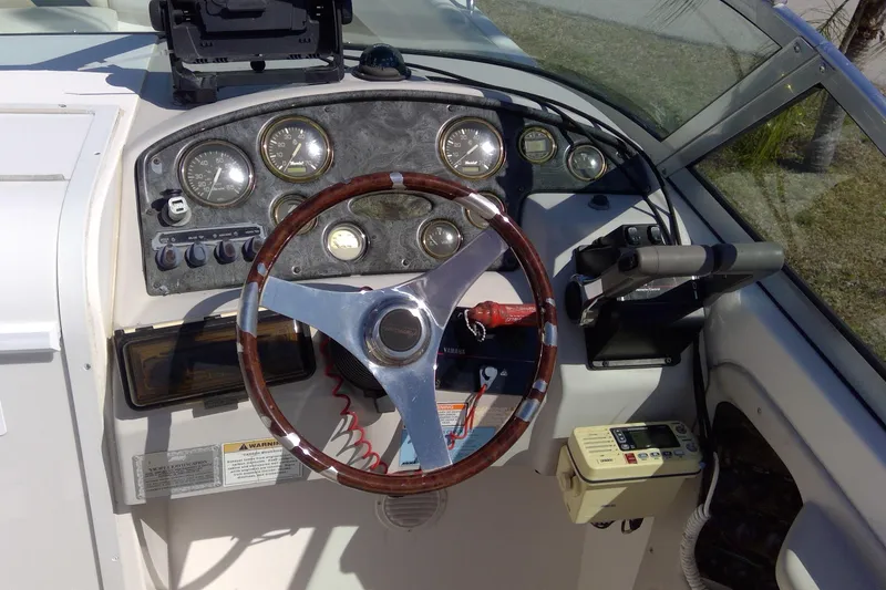 Slide: The Image of 2004 Hurricane SunDeck 260 OB boat dashboard with steering wheel and instrument panel. - 9
